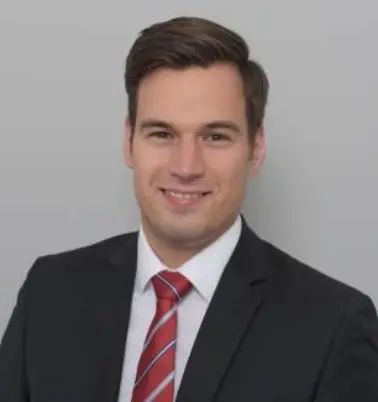 Maximilian Resch schaut nach vorne und lächelt. 