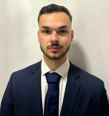 Stipe Kostic schaut nach vorne und lächelt.